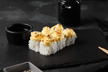 Elegant Presentation of Baked Sushi Roll with Cheese Mousse Topping in Dark, Minimalist Setting