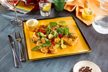 Colorful Seafood Assortment with Shrimps, Scallops, Fish, Avocado, and Cherry Tomatoes on Yellow Plate