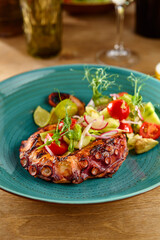 Grilled Octopus with Fresh Tomato Salad on Rustic Blue Plate in Warm Natural Lighting