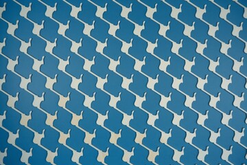Fototapeta premium Blue and white pattern. Abstract background with repeated pattern of white shapes on blue surface.