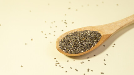 Heart-shaped wooden spoonful of chia seeds.