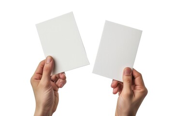 Obraz premium A pair of hands hold up two blank white presentation cards, ready for notes or information