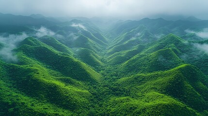 Fototapeta premium Aerial view of a mountainous valley landscape with layered mountains and lush green valleys.