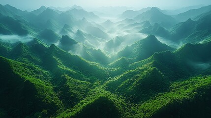 Aerial view of a mountainous valley landscape with layered mountains and lush green valleys.