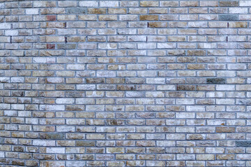 Light brown and gray stone wall with light grout. Beautiful old stone pattern, background. Wallpaper