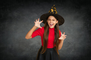 Teen portrait in Halloween hat. Halloween witch teen girl. Little girl witch. Kid witch celebrates...