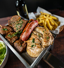 grilled chicken, beef, anticucho, chorizo and hot dog, served with french fries, fresh salad and a bottle of wine.