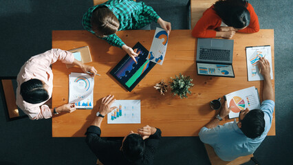Top down view of business woman explain and present financial chart. Diverse group discuss and listen presentation about stock market statistic at meeting table with investment graph. Convocation.