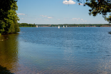 Sailboats on water in Sweden. Children sailing small sailboats (catamarans) on a lake.