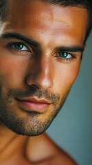 Obraz premium Close-up of a young man with striking blue eyes and well-groomed facial hair showcasing confidence and charisma indoors