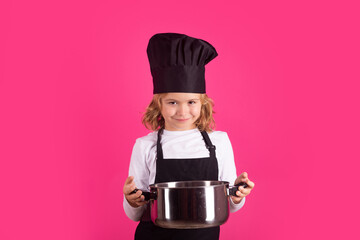 Child chef cook with cooking pot. Chef child preparing healthy food. Studio portrait of child with...