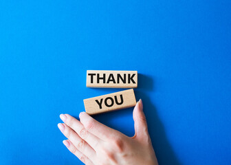 Thank you symbol. Wooden blocks with words Thank you. Businessman hand. Beautiful blue background. Business and Thank you concept. Copy space.