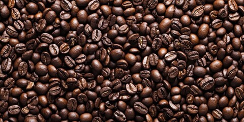 Obraz premium High-resolution close-up of coffee beans creating a textured background from a top view perspective