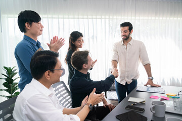 Diverse group of office employee worker shake hand after making agreement on strategic business marketing meeting. Teamwork and positive attitude create productive and supportive workplace. Prudent