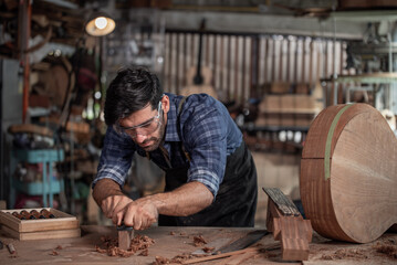 Luthier creating a guitar and using tools in a traditional