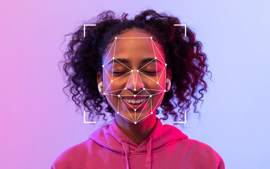 A young black woman with curly hair smiles while wearing wireless earbuds and experiencing facial...