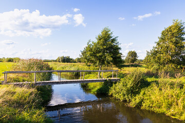 Small wooden walkway over a small river - Barneveldse beek, in the rural area near the village of Stoutenburg.
