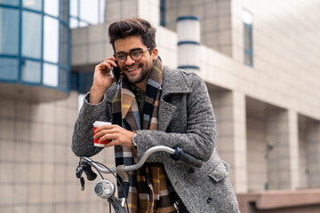 Smiling Businessman with Bicycle and Takeaway Coffee on City Call