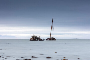 SS or MV Kaffir Clyde puffer wreck rusting north of Ayr Harbour with seaweed foreground - Long...