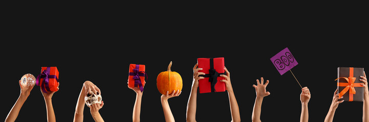 Women with Halloween gifts and word BOO on dark background