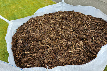 1 ton bag of ornamental bark mulch for garden on lawn at road kerbside