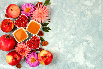 Autumn banner with honey, apples, pomegranates, flowers, dried fruits on concrete background,...