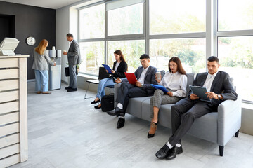 Business people waiting for their turn in office hall