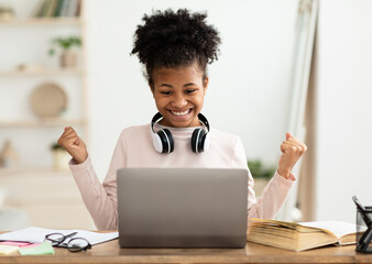 Little Winner. Excited Black Girl At Laptop Gesturing Yes Getting A-Grade During Webinar At Home. Online School Tests Concept