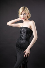 Fototapeta premium Expressive young blonde under a bob in the studio. In a black corset and dress.