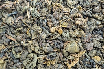 close-up of curled green tea leaves. food background. Tea drinking tradition of China and India. Macro photo, top view, flat lay