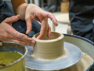A close-up of a craftsman making an object out of clay on a potter's wheel. Handmade, hobby, hobby