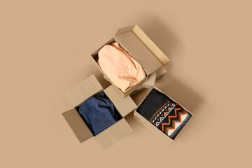 Wardrobe boxes with clothes on beige background
