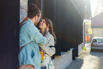 Young trendy hipster couple standing on city street and flirting.