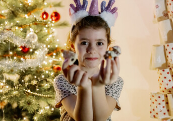 A girl shows a gift from the pocket of a wall advent calendar.