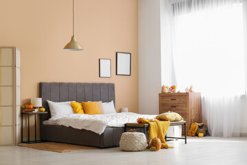 Stylish interior of modern bedroom with autumn decor