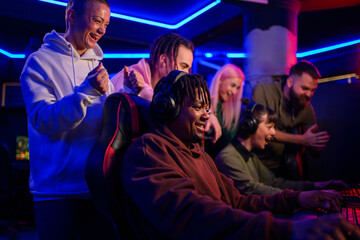 Side view of multicultural gamer playing match in gaming room.