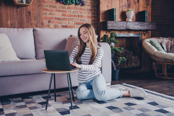 Obraz premium Full body photo of lovely teen lady sit floor netbook relax dressed striped garment spend pastime spacious house indoors room