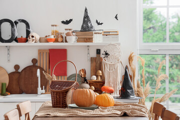 Halloween pumpkins with basket on table in kitchen
