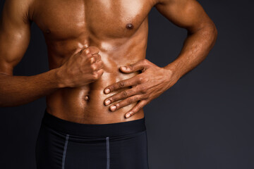 Naked Torso. Unrecognizable black man showing muscular body and six pack abs over black background...