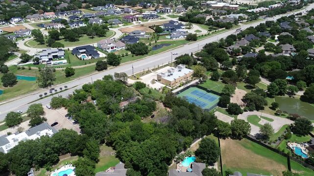 Tennis court in upscale residential neighborhood along West Southlake Boulevard, Keller with luxury mansion houses swimming pool, water fountain pond, suburbs Dallas Fort Worth metroplex, flyover