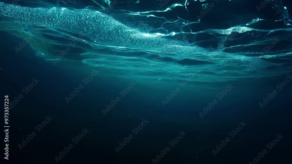 Poster Rays of sunlight are filtering through the surface of a deep blue ocean, creating an ethereal and otherworldly underwater scene