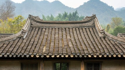 A traditional Chinese tiled roof with decorative details against a backdrop of misty mountains.