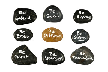 Fototapeta premium Handwritten be different inspirational uplifting motivational messages phrases on black stone pebbles with positive vibe to lift your spirit isolated