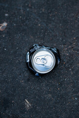 Flat aluminium beverage can on the ground.