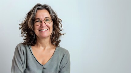 Obraz premium Confident middle-aged woman with a warm smile standing on white background
