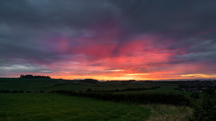 Dramatic sunset across farm fields with Goat Fell Isle of Arran on horizon
