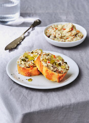 Deliciously crafted spread on toasted bread served with a side of creamy dip for a delightful tasting experience