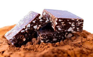 Close-up of dark chocolate pieces and cocoa powder on white or transparent background.Used for gourmet confectionery advertisements. Chocolate background.Wallpaper design for recipe magazines and cook