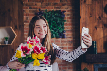 Photo of attractive teen female hold flowers bouquet tulips take selfie photo dressed striped...
