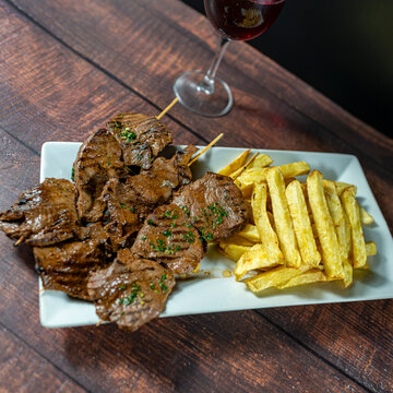 heart anticucho with french fries, strawberry salad, homemade creams and a glass of wine